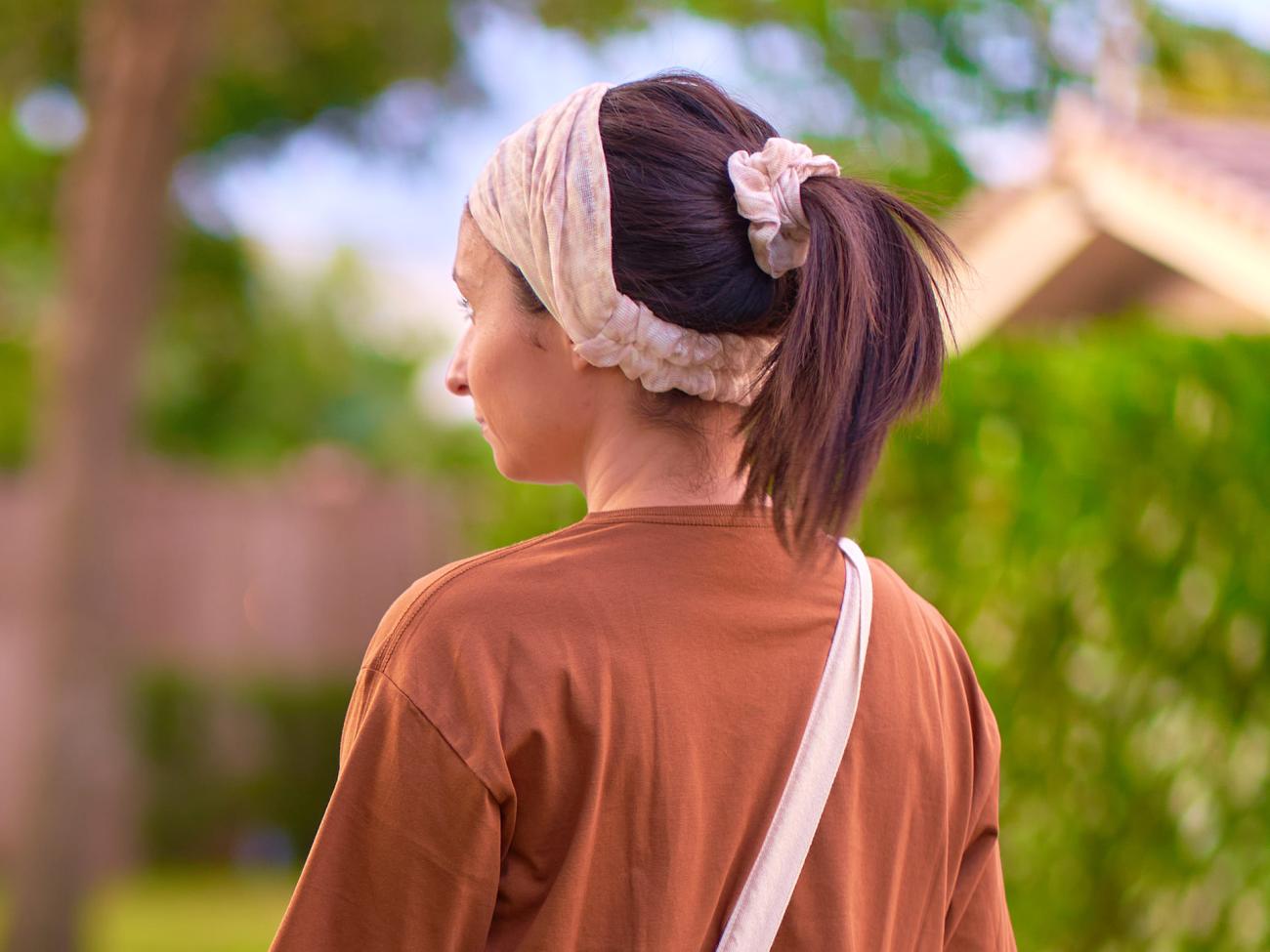A woman wearing a headband and scrunchie. Sustainable summer.