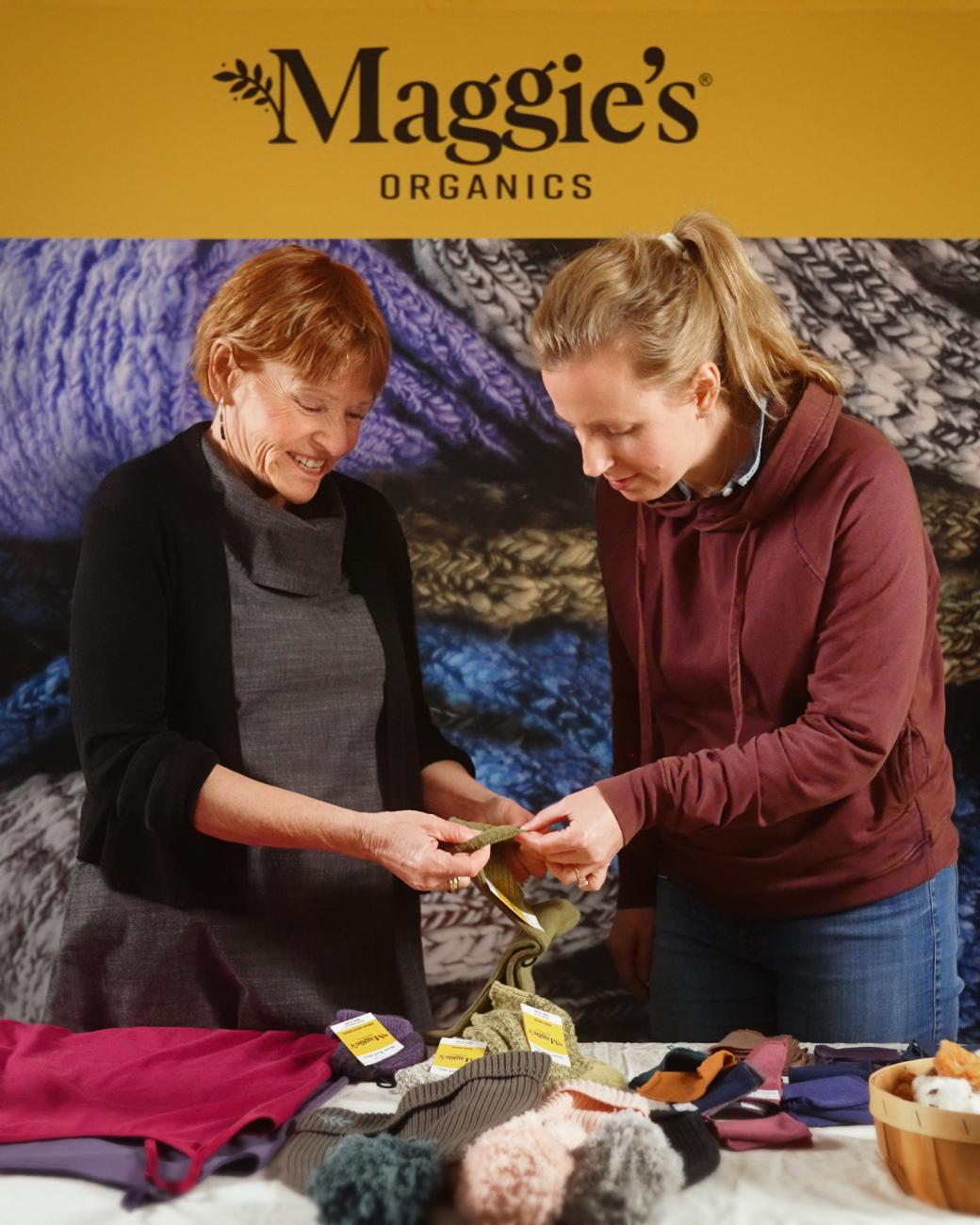 Bená Burda and Sarah Queen look at a pair of socks from the company Maggie's Organics.