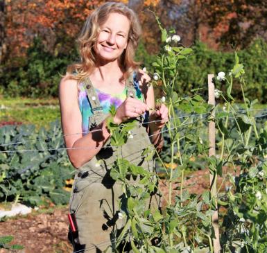 Lisa standing buy a trellised bean plant on an autumn day