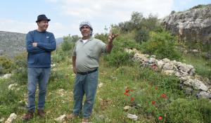 Nasser Abufarha and a Palestinian farmer talking in a field.