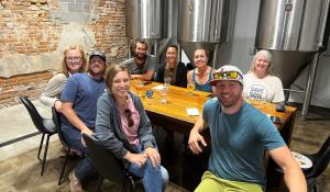 Brian James and Green America team members sitting around a table at a brewery.