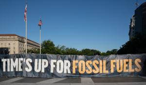 The 2021 J30 climate protest in Washington, DC. Groups gather with a sign that read "time's up for fossil fuels," protesting things like anti-ESG bills.