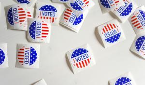 I voted stickers scattered across a white table.