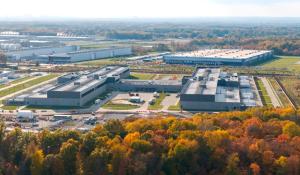 wide shot of a data center in Ohio from a hillside, so you can see the entire metropolis of warehouses. In the foreground are orange and yellow trees in the fall.